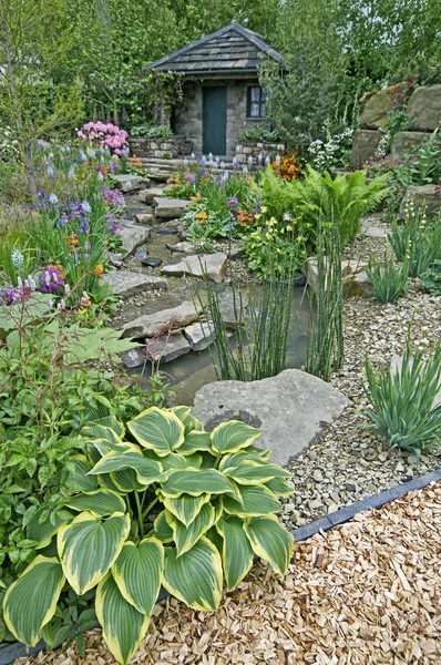 Wiejski ogród wiejski w zalesionej skale z kolorowym sadzeniem — Zdjęcie stockowe