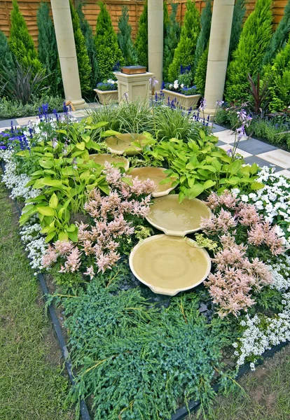 A water feature in a decorative flower border