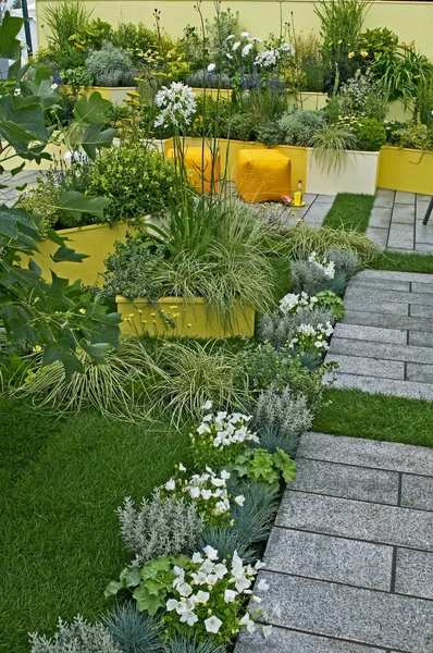 Un colorido jardín del patio contemporáneo con asientos, frontera elevada — Foto de Stock