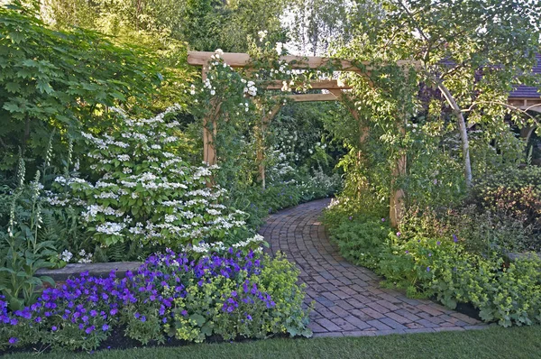 Stylisé comme un jardin traditionnel britannique typique avec des fleurs, des plantes et des arbustes — Photo