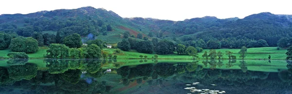 A água tranquila de Loughrigg Tarn perto de Windermere no Lake District Inglaterra — Fotografia de Stock