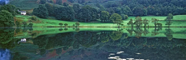 L'eau calme et paisible de Loughrigg Tarn près de Windermere dans le Lake District Angleterre — Photo