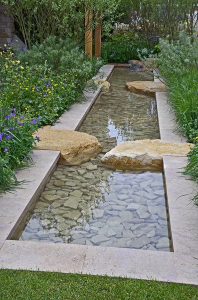 Jardin d'eau moderne avec ruisseau coulant avec rochers et rocailles — Photo