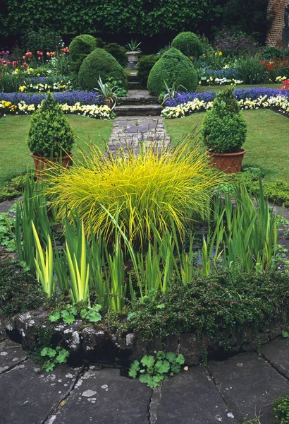 Sunken Garden with central pool and selection of grasses and topiary in containers in a country house garden — Stock Photo, Image