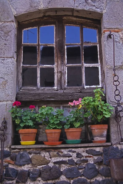 An old window frame decorated with potted Geraniums in Normandy — Stock Photo, Image