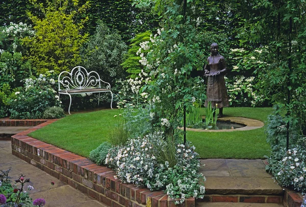 In a country house raised garden with water feature and life sized female sculptured figure and secluded seating — Stock Photo, Image