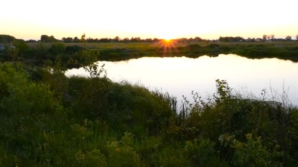 Hermosa puesta de sol junto al lago. La cámara se cae — Vídeos de Stock