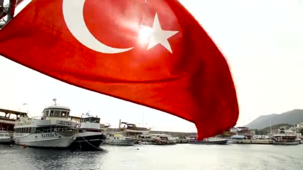 Bandera de Turquía en el fondo del mar. El sol brilla a través de la bandera. Se desarrolla en el viento — Vídeo de stock