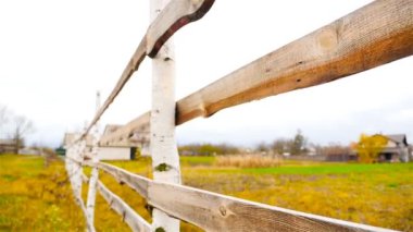 Kamera ahşap çit taşır. Ağır çekim. Sonbahar manzara