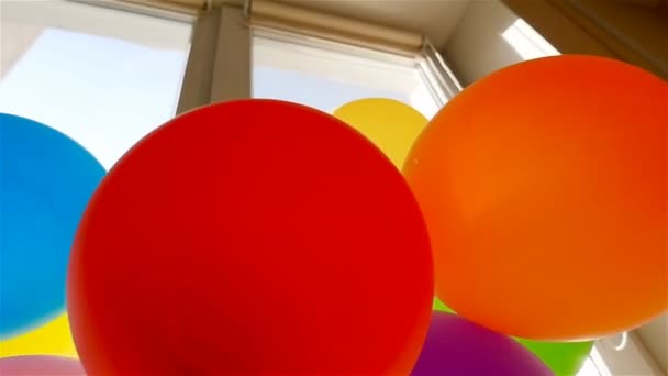 The balloons hang tied near the windows. Red, blue, green, purple, yellow, orange. Slow Motion — Stock Video