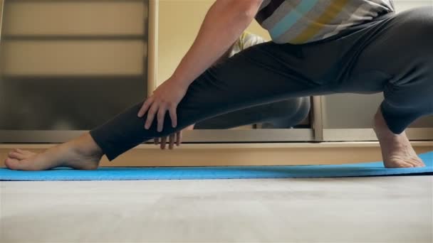 En sportig man är stretching benen. Slow motion — Stockvideo