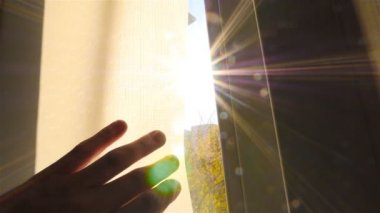 Eller perde penceresinde açın. Penceredeki güzel güneş ışınları. Ağır çekim. Yakın çekim