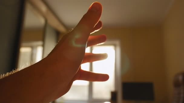 La mano en el fondo del sol muestra un gesto bien. El interior de la habitación. En cámara lenta. Primer plano — Vídeos de Stock