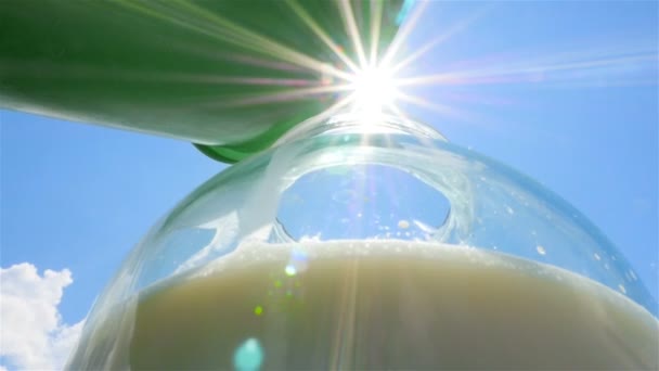 在太阳的背景下, 将新鲜的牛奶倒入玻璃罐中。慢动作。特写 — 图库视频影像