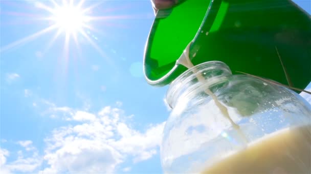 新鮮なミルクは、ガラス瓶に注がれています。スローモーション。クローズ アップ — ストック動画