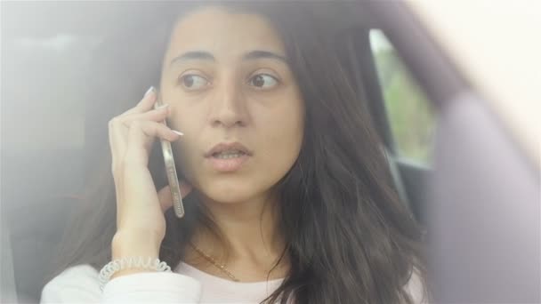 Menina jovem e bonita falando ao telefone no carro. Close-up. Movimento lento — Vídeo de Stock