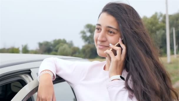 Hermosa chica hablando por teléfono cerca del coche. Primer plano — Vídeos de Stock