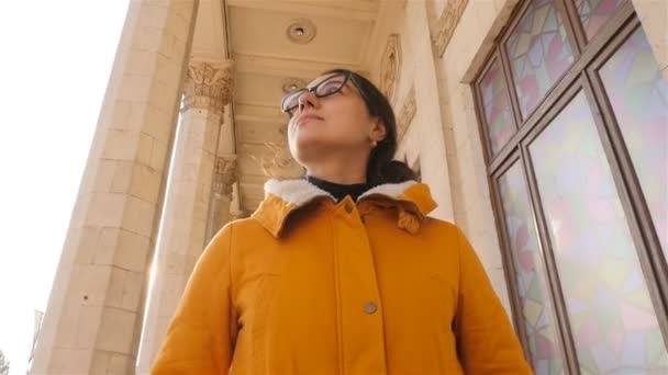 The girl walks past beautiful columns. The bright rays of the sun. Slow motion. Close-up — Stock Video
