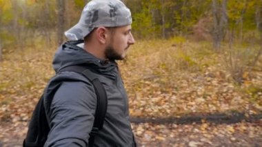 Şapkalı adam sonbahar Ormanda yürür. Ağır çekim. Güzel bir yer. Bir kişi