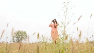 Güzel bir kız alan yürür. Manzara fotoğrafçılığı. Uzun saçlı. Yavaş çekim. İnce yapılı esmer elbiseli