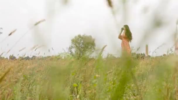 Hermosa morena en un vestido con una cámara. La cámara avanza. Movimiento lento — Vídeos de Stock