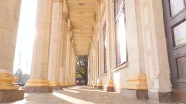 Güzel sütunlar. Yüksek bina. Ağır çekim. Kamera çekimde. Güneş ışınları. Ukrayna. Kiev. 11 07 18 park Fuar