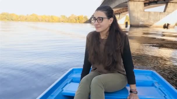 La chica se sienta en un barco balanceándose sobre las olas. En cámara lenta. Hermoso clima . — Vídeos de Stock