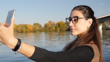 Genç bir kız su yakınında bir selfie yapar. Close. Yavaş hareket