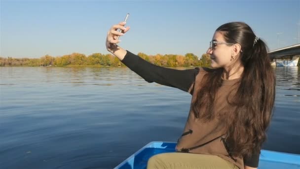 Piękna dziewczyna robi selfie w łodzi. Wygląd modelu. Ładny uśmiech. Malowniczy krajobraz — Wideo stockowe