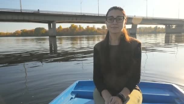 Menina encantadora em um barco no fundo dos raios de sóis. Um lindo sorriso no rosto. Lindo lugar. Movimento lento — Vídeo de Stock