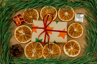 Noel süsleri. Çamın dalları, tarçın ve Kuru portakal ve hediye kutuları bir ahşap yüzeye.