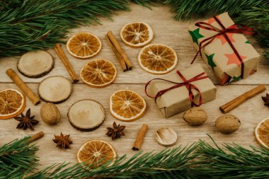 Noel süsleri. Çamın dalları, tarçın ve Kuru portakal ve hediye kutuları bir ahşap yüzeye.