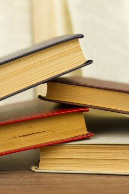 Ahşap bir masa üzerinde çok renkli eski kitaplar. Eğitim ve öğretim kavramı