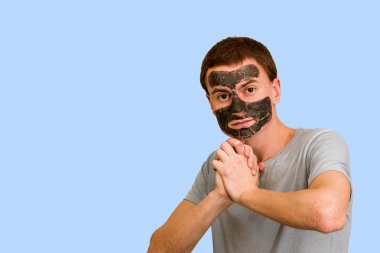 Adam bir şişe su mavi bir arka plan üzerinde tutar. Sağlıklı yaşam kavramı