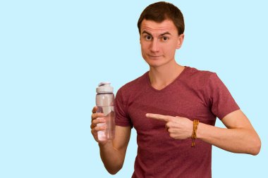 Adam bir şişe su mavi bir arka plan üzerinde tutar. Sağlıklı yaşam kavramı