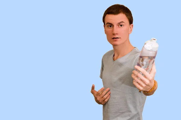 Tipo Sostiene Una Botella Agua Sobre Fondo Azul Concepto Estilo —  Fotos de Stock