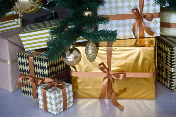 Beautifully decorated house with a gold tree and presents at Christmas.