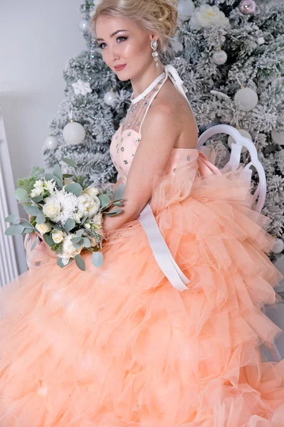 young blonde woman in fashion pastel dress posing indoors, Christmas concept