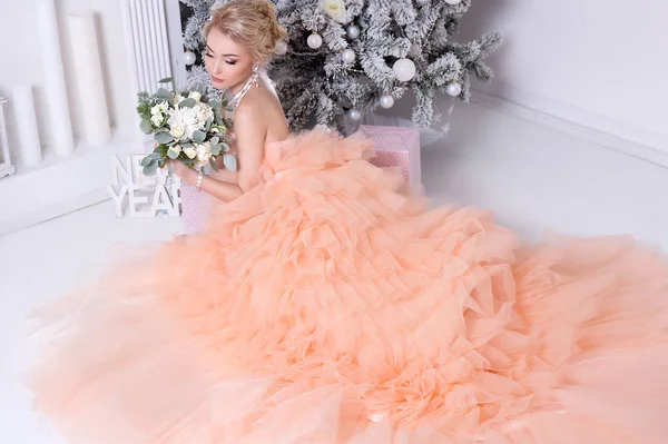 young blonde woman in fashion pastel dress posing indoors, Christmas concept