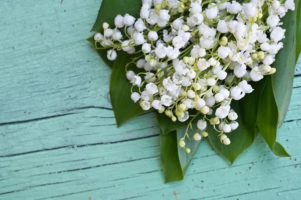 Spring bouquet of Lily of the valley on wooden background. Decorative composition