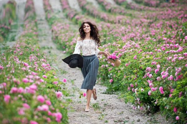 young woman walking at pink roses field at daytime