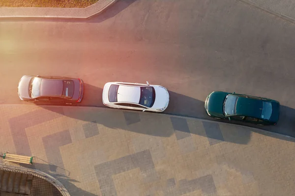 Üç araba yolda park edilmiş.