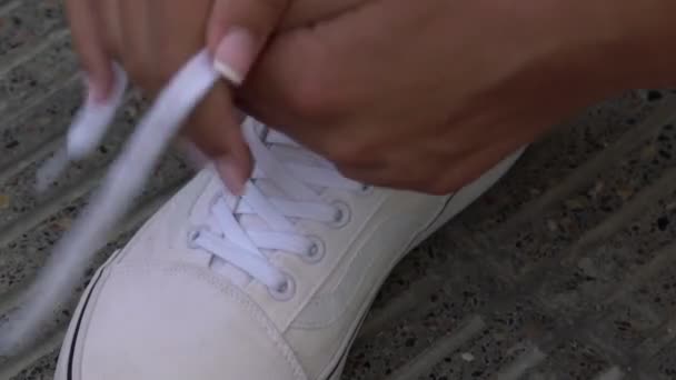 Young woman hands tie white laces on floor close view — Stock Video