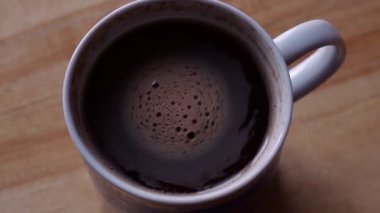 koyu kahve köpük kahverengi masada mavi fincan döner