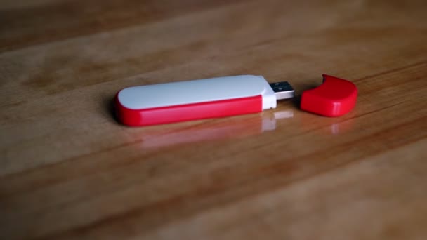 Flash drive com tampa encontra-se na mesa de madeira marrom polido — Vídeo de Stock