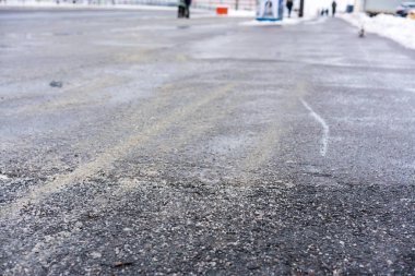 bir toplu taşıma durağı yakınında yayalar için kaygan kış asfalt yolu güvenlik için kum ve tuz serpilir