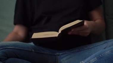 siyah t-shirt ve mavi kot genç kadın kitap açar