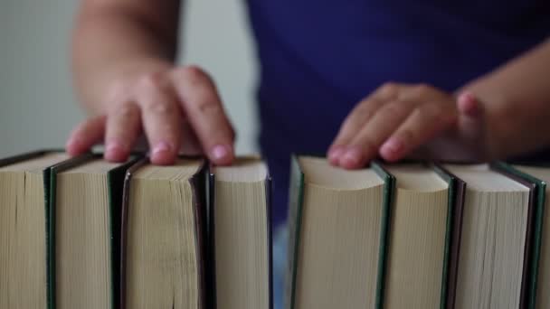 Jovem mulher com manicure rosa escolhe livro e leva um — Vídeo de Stock