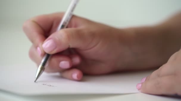 Jonge vrouw zelfverzekerd hand met roze manicure schrijft — Stockvideo