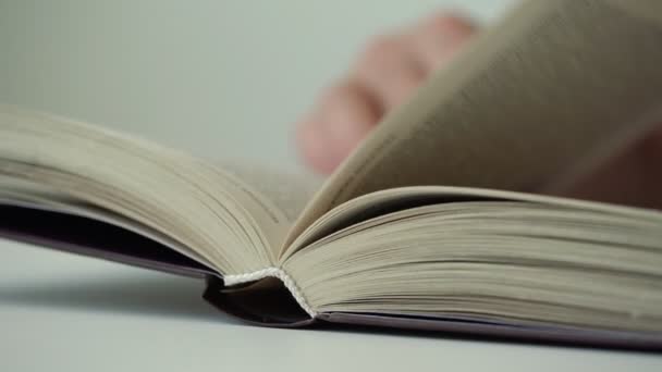 흐릿한 사람의 손이 책 페이지를 뒤집고 줄에 손가락을 실행 — 비디오